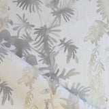 Draped fabric in an watercolor palm frond pattern in shades of beige and tan. 