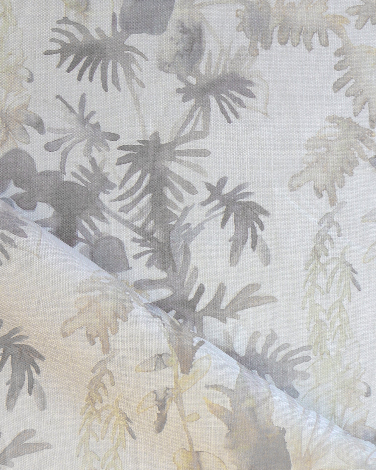 Draped fabric in an watercolor palm frond pattern in shades of beige and tan. 