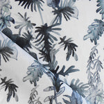 Draped fabric in an watercolor palm frond pattern in shades of dark blue. 