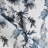 Draped fabric in an watercolor palm frond pattern in shades of dark blue. 