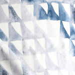 Detail of draped fabric in a painterly check pattern in shades of blue, gray and white.