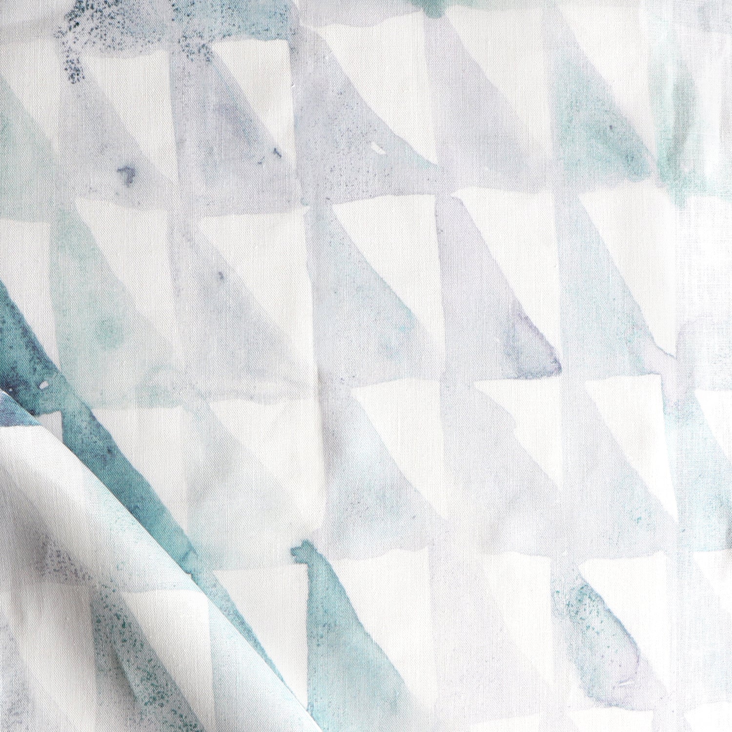 Detail of draped fabric in a painterly check pattern in shades of green and white.
