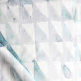 Detail of draped fabric in a painterly check pattern in shades of green and white.