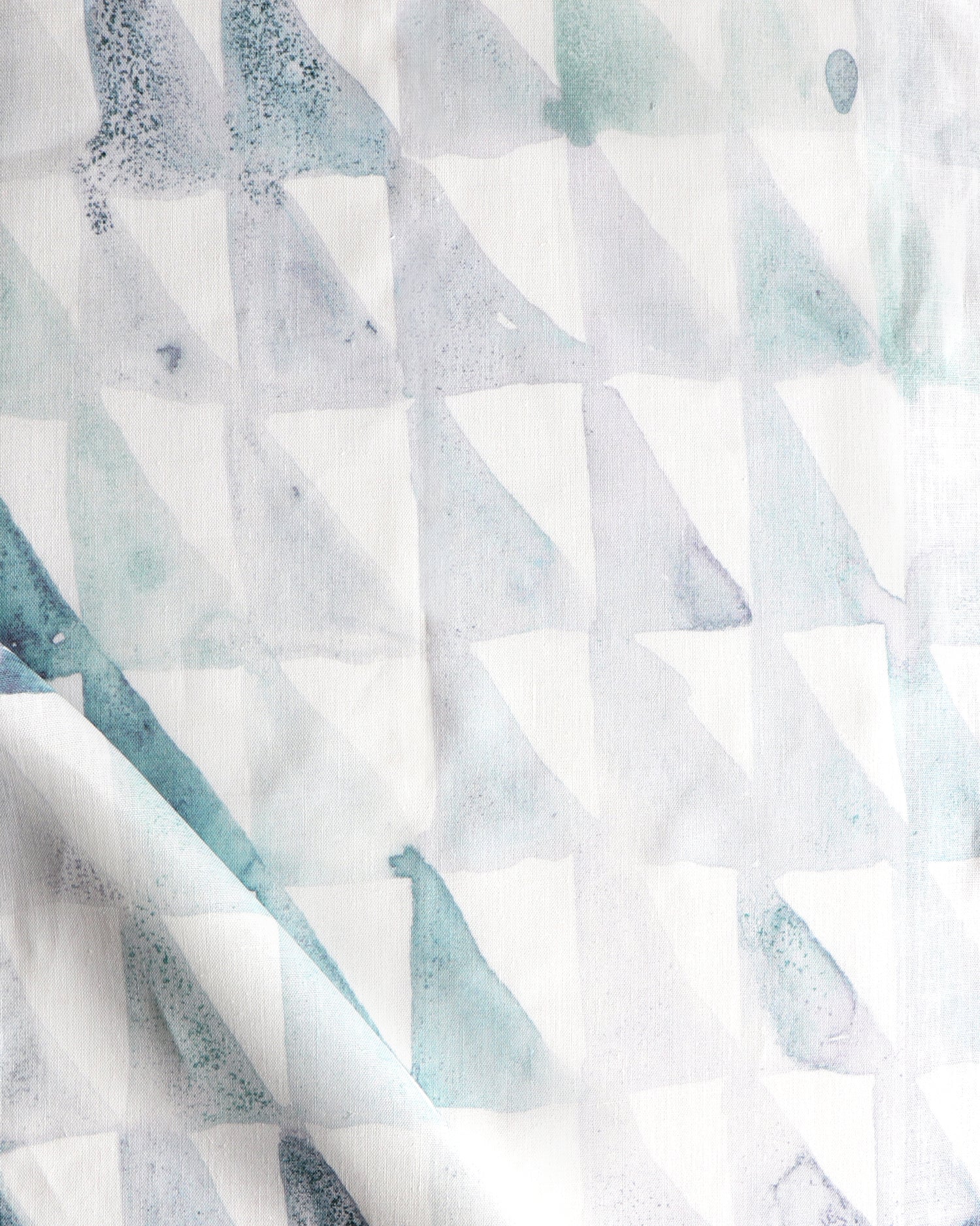 Detail of draped fabric in a painterly check pattern in shades of green and white.