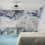 Modern simple bedroom scene with an etheral wallpaper mural in shades of blue. 
