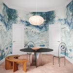 Ornate dining room scene with an ethereal watercolor mural in shades of teal and grey. 