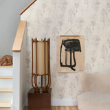 Staircase with wallpaper in watercolor tree print in shades of tan and gray on a white field.
