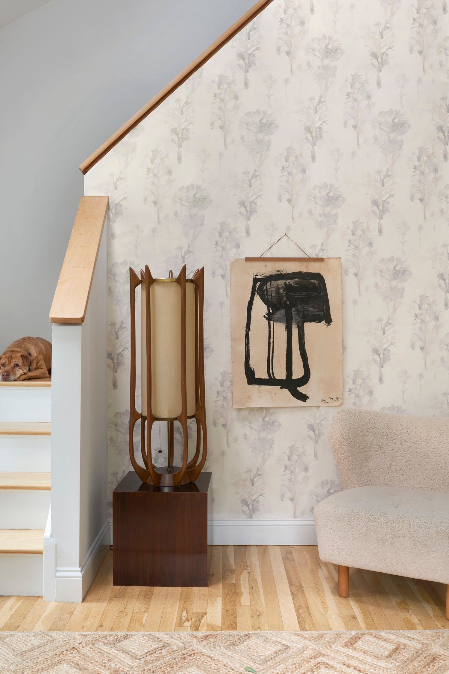 Staircase with wallpaper in watercolor tree print in shades of tan and gray on a white field.
