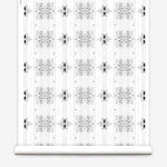 Wallpaper roll in a minimalist ikat pattern in shades of gray on a white field.