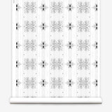 Wallpaper roll in a minimalist ikat pattern in shades of gray on a white field.