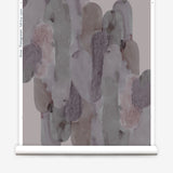Wallpaper roll  in watercolor elongated pill pattern in moody purple on a white field.