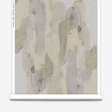 Wallpaper roll in watercolor elongated pill pattern in tan, taupe and grey on a white field.