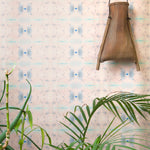 Wallpaper install in repeating ink blot print in shades of purple framed by a plant and hanging basket.