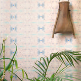 Wallpaper install in repeating ink blot print in shades of purple framed by a plant and hanging basket.