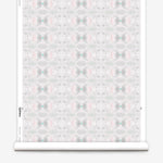 Wallpaper roll in a repeating ink blot print in shades of gray with turquoise and pink accents.