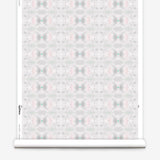 Wallpaper roll in a repeating ink blot print in shades of gray with turquoise and pink accents.