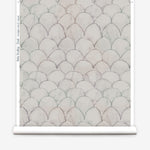 Wallpaper roll in a watercolor linear scallop pattern in navy on a cream field. 