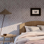 Wallpaper roll in a watercolor linear scallop pattern in purple on a lilac field. 