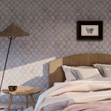 Wallpaper roll in a watercolor linear scallop pattern in purple on a lilac field. 