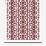 Wallpaper roll in a watercolor ikat stripe print in shades of white on a red field.