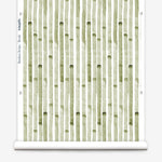 Wallpaper roll in a painterly stripe print in olive on a white field.