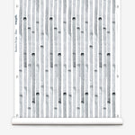 Wallpaper roll in a painterly stripe print in gray on a white field.