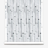 Wallpaper roll in a painterly stripe print in gray on a white field.