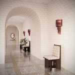 Arched hallway with terrazzo floors fully wallpapered in a texutral watercolor pattern in pastel pink. 