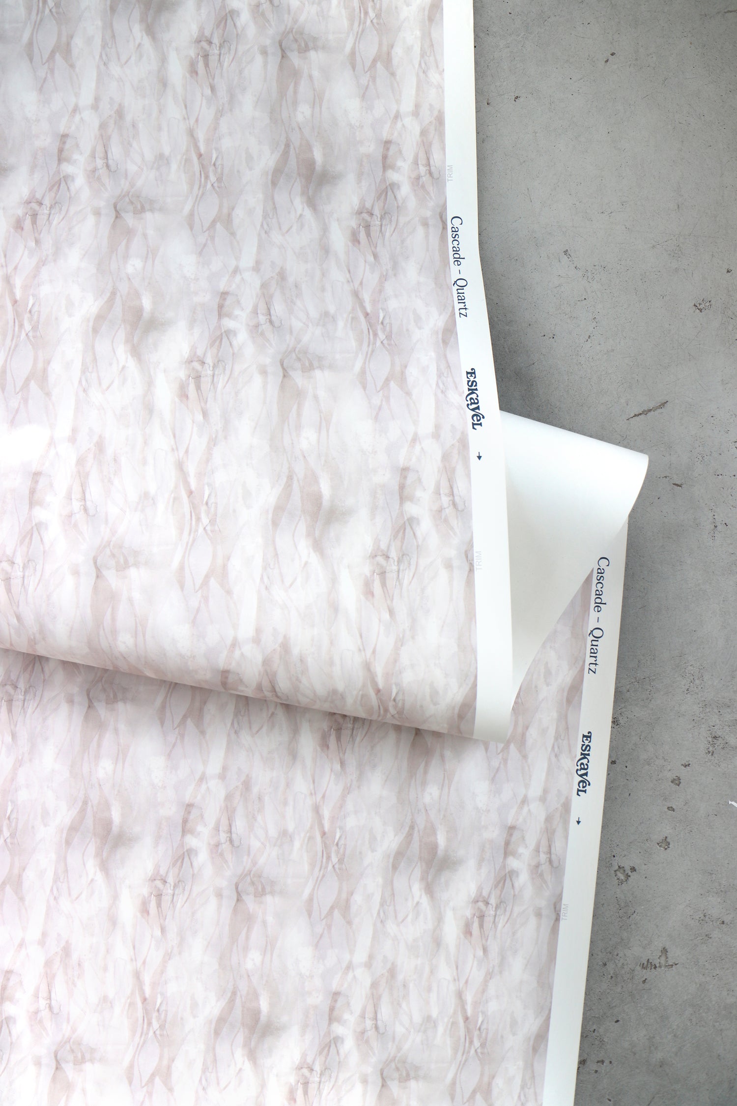 Draped Wallpaper roll in a layered squiggle watercolor pattern in shades of pastel pink. 