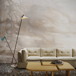 Striped couch, floor lamp and wooden coffee table against warm taupe watercolor mural wallpaper. 