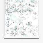 Wallpaper roll in a watercolor branch and floral pattern in teal green on a white field.