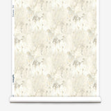 Wallpaper roll in a painterly tree print in gray and tan on a white field.