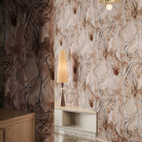 Interior hallway with low table and lamp with wallpaper in warm brown with teal abstract pattern. 