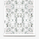 Wallpaper roll in a watercolor paint blotch print in gray and turquoise on a white field.