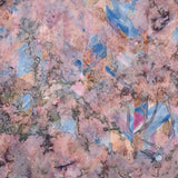 Detail of wallpaper in a painterly tree print in pink, orange, gray and blue.