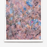 Wallpapper roll in a painterly tree print in pink, orange, gray and blue.