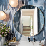 Powder room sink and mirroy aginsta a watercolor mural in dark blue. 
