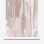 Wallpaper mural roll in a watercolor paint print in shades of pink, brown and gray on a cream field.
