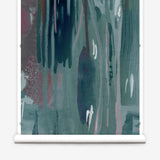 Wallpaper mural roll in a watercolor paint print in shades of pink, purple and turquoise on a blue field.