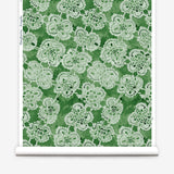 Wallpaper roll with green watercolor lace floral pattern on a white background.