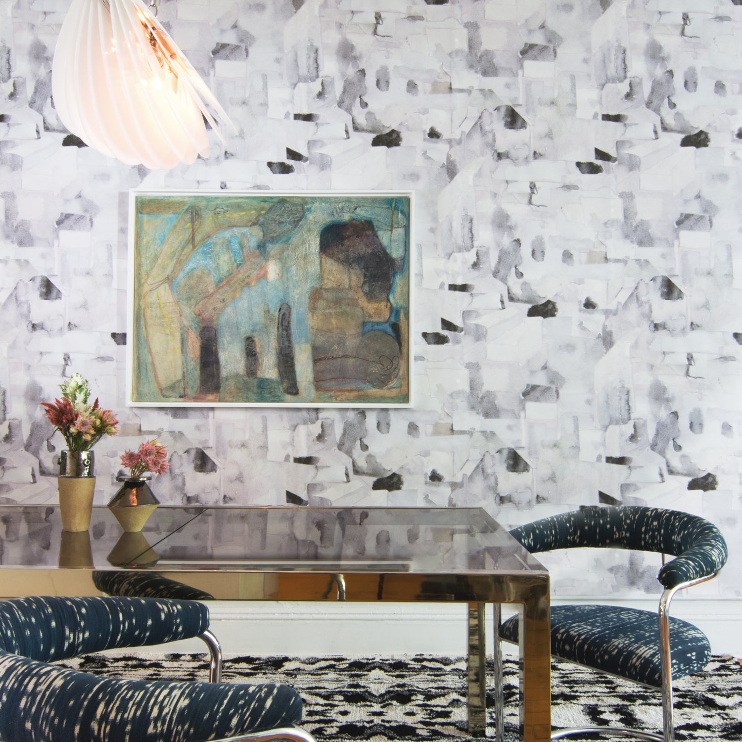 Dining room with modern furniture against wallpaper in a textural paint blotch print in shades of gray and blue on a light gray field.
