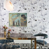 Dining room with modern furniture against wallpaper in a textural paint blotch print in shades of gray and blue on a light gray field.
