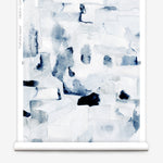 Wallpaper in a textural paint blotch print in shades of black and navy on a white field framed by a black bench with red flowers and black radiators. 