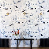 Wallpaper roll in a textural paint blotch print in shades of black and navy on a white field.