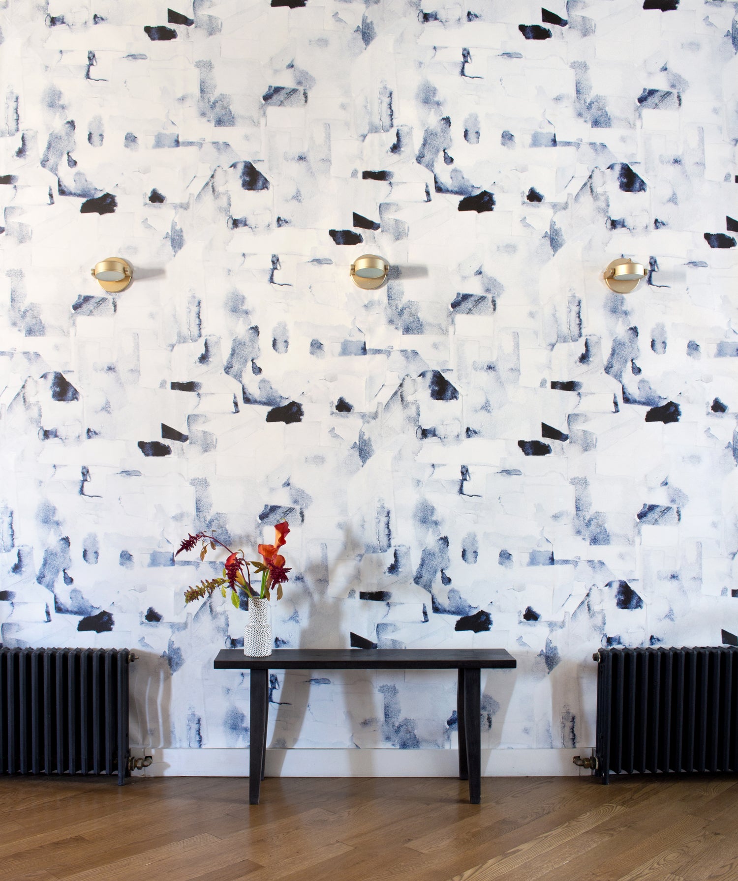 Wallpaper roll in a textural paint blotch print in shades of black and navy on a white field.