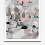Wallpaper roll in a textural paint blotch print in shades of pink and gray on a white field.