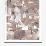 Wallpaper roll in a textural paint blotch print in shades of brown and tan on a white field.