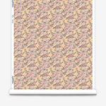 Wallpaper roll in an undulating abstract watercolor motif in pink, purple, tan and charcoal. 