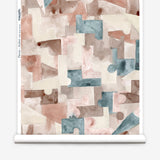 Wallpaper roll in a geometric puzzle piece watercolor pattern in blush, grey and teal. 