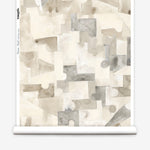 Wallpaper roll in a geometric puzzle piece watercolor pattern in beige and grey. 